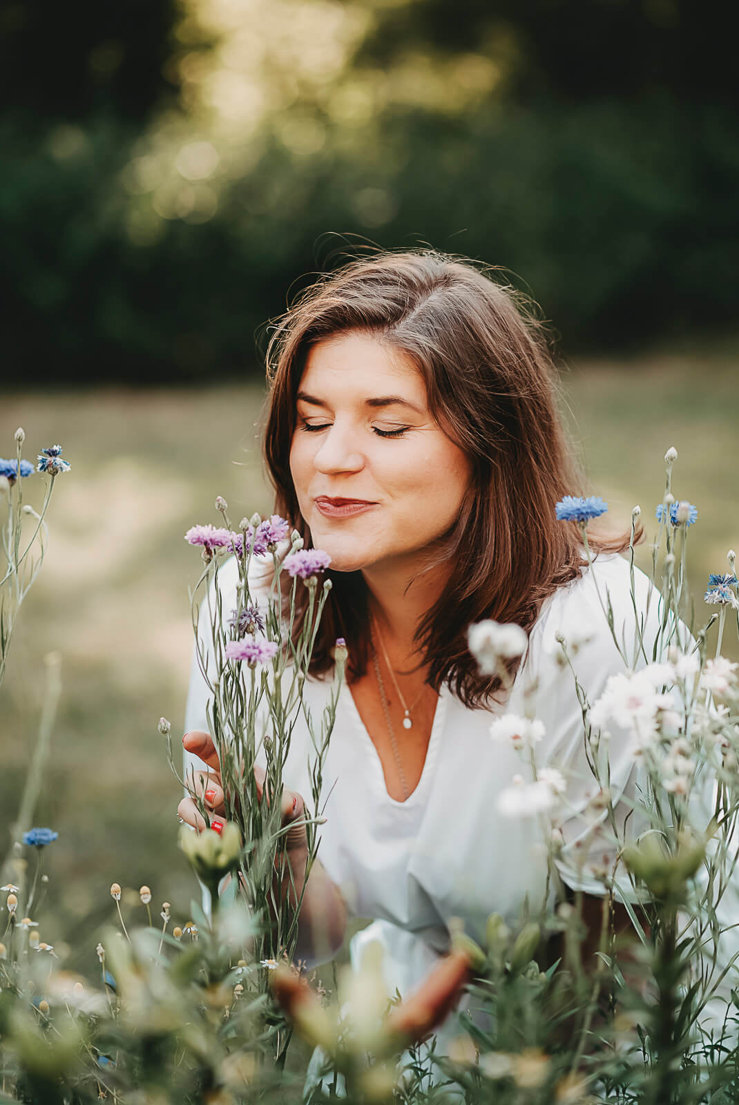 Frau schnuppert an Wildblumen. Familienfotografie Wetterau