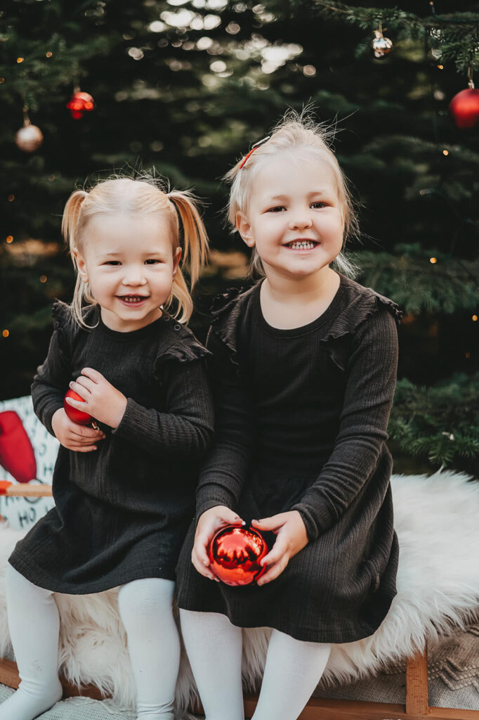 Geschwister im Kleid spielen mit Christbaumkugeln. Familienfotografie Wetterau
