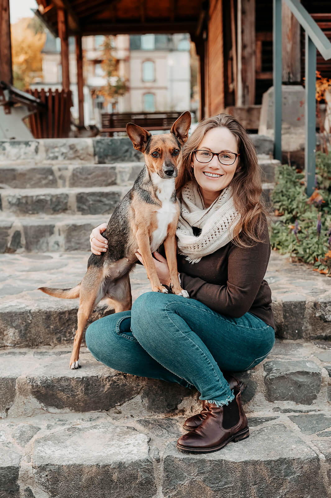 Frau mit Hund sitzt auf einer Treppe Familienfotografie Wetterau